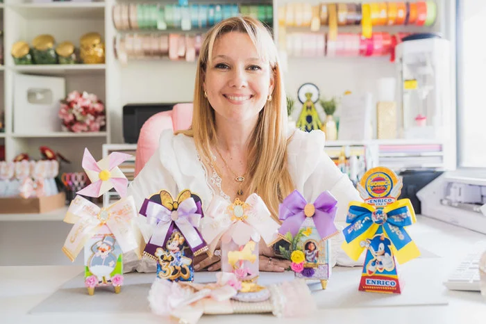 Carla em seu ateliê com peças de papelaria personalizada